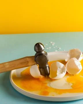 Art concept for Easter or building materials. Broken eggs with a hammer Foto stock