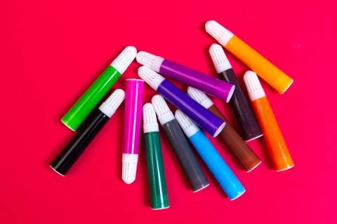 Art creativity and design concept. Colored markers on red background. Stock Photos