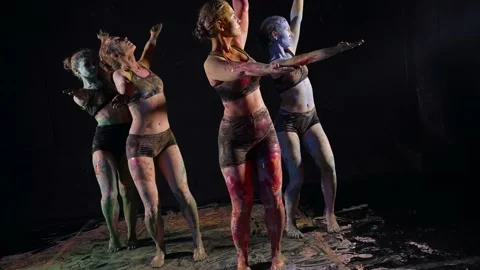 Art dancers practice performing with body paint in a black studio Vidéo 155580149