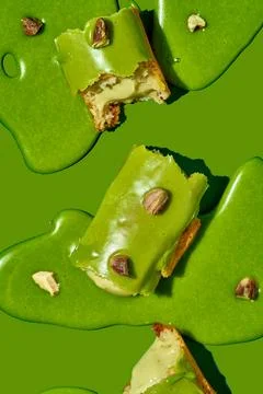 Art with an eclair. Broken eclair in puddles of icing on green background. .. Stock Photos