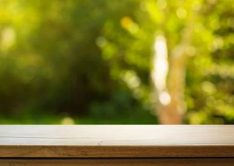 Art Empty wooden deck table on sunny green garden background Stock Photos