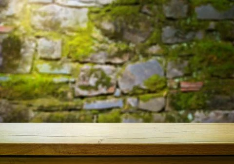 Art Empty wooden deck table on old stone wall background Stock Photos