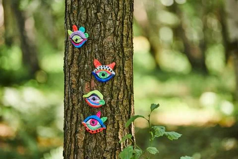 Art object of human eyes on tree trunk in green forest background, trees si.. Stock Photos