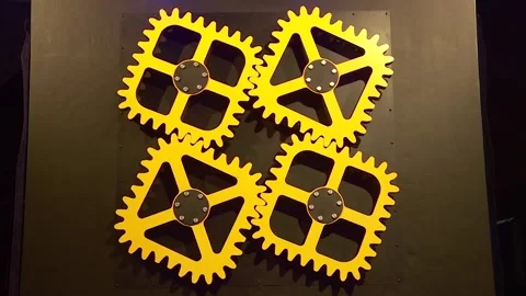 The art object is a mechanism of yellow square gears in motion Stock Footage 285397934