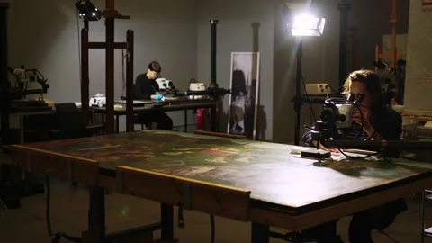 Art restorers work with drawings using magnifying equipment Stock Footage 133243453