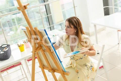 Art school, creativity and leisure concept - student girl or young woman artist Stock Photos