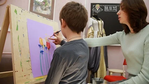 An art school lesson, the teacher explains the boy's painting Vidéo 102242523