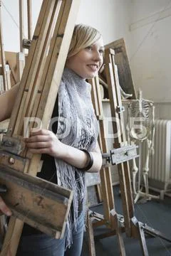 Art Student Carrying Easel In Studio Stock Photos