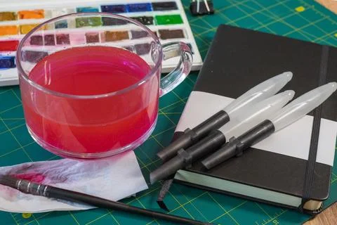 Art supplies ready for creative process with watercolor paint mixed in wate.. Stock Photos