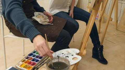 Art teacher and her apprentice working on a watercolor picture Stock Photos