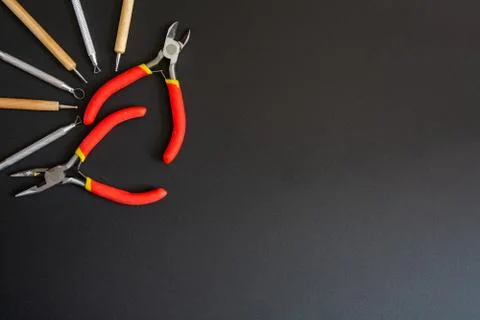 Art tools in a top left corner. On a black background. Small pliers, cutting Stock Photos