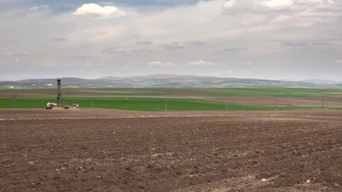 Artesian well drilling rig working on treeless farmland, opening water borehole Stock Footage 339819059