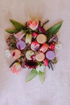Artful array of colorful macarons with vibrant spring flowers Foto stock