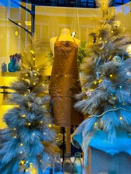 Artful store window display featuring brown apron and blue christmas trees Stock Photos