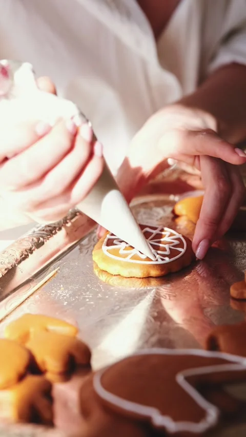 Artfully Decorating Gingerbread Cookies with Icing for Holiday Celebrations Stock Footage 325055615
