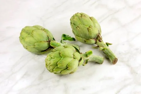 Artichokes on white marble texture with copyspace Foto stock