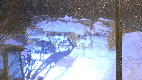 Articulated front end loader used for snow removal at night during snowfall Stock Footage 103677992