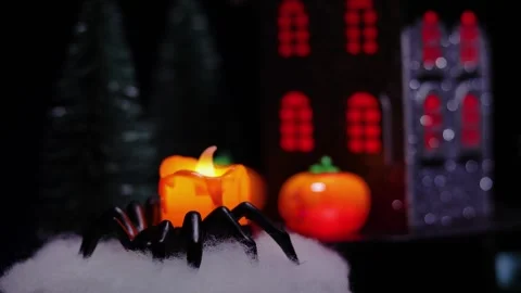 Artificial candle in a spider-shaped candlestick against of a rotating house Stock Footage 319339392