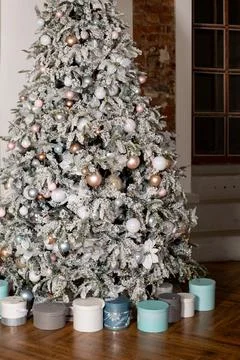 Artificial Christmas tree in a bright interior with silver, pink, bronze balls Stock Photos