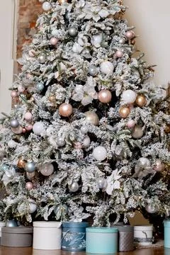 Artificial Christmas tree in a bright interior with silver, pink, bronze balls Stock Photos