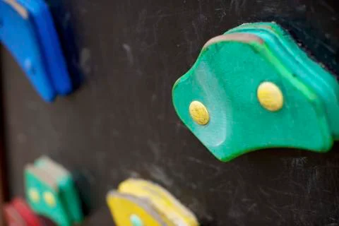 Artificial climbing wall covered with colored holds in an adventure playground. Stock Photos