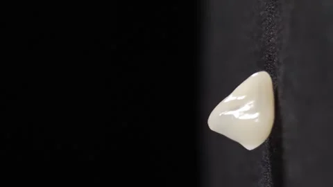 Artificial dental crown model shot on black background. Dental teeth veneers Stock Footage 317629483