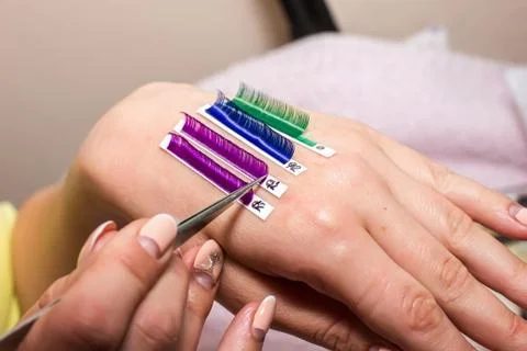 Artificial eyelash extensions, the master's hand, eyelash extension procedure Stock Photos