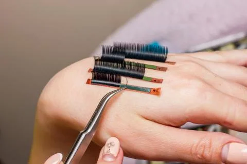 Artificial eyelash extensions, the master's hand, eyelash extension procedure Stock Photos