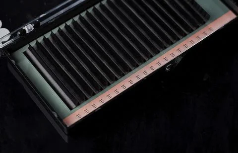 Artificial eyelashes for extension in a box, used for eye makeup on a black b Stock Photos