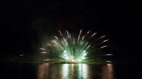 Artificial Fireworks Display with reflections on water surface in 6k Stock Footage 95747147