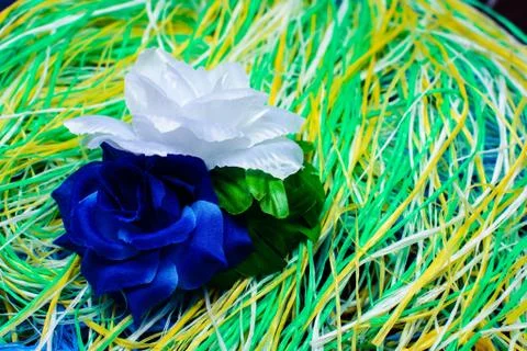 Artificial flower on a substrate of multi-colored thread Stock Photos
