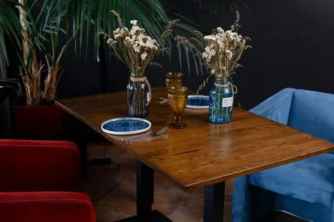 Artificial flower vase on table top over blurred image of modern workplace Stock Photos