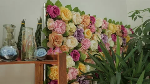 Artificial flowers assembled in an installation on the wall Stock Footage 231027434