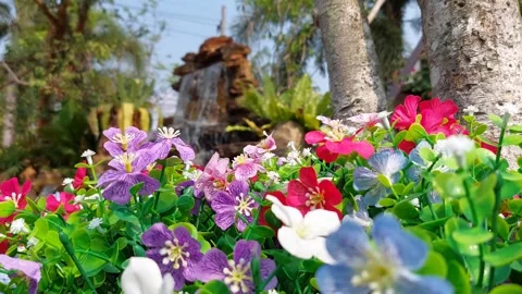 Artificial flowers in front of the waterfall Stock Footage 263472114