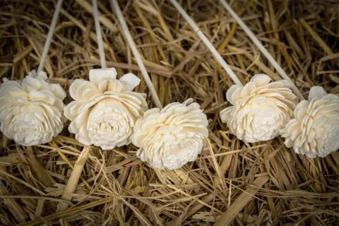Artificial flowers on straw Foto stock