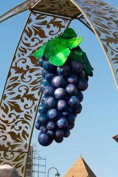 Artificial grapes. A giant artificial grape attached to a metal arch. Wine .. Stock Photos