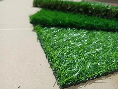 Artificial grass pieces. Samples of flooring. Artificial grass close-up. Stock Photos