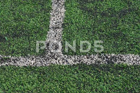 Artificial green grass soccer field made with plastic and rubber Stock Photos