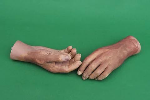 Artificial hands on green background. Stock Photos