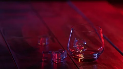 Artificial ice cubes fall into an empty glass slow motion. Stock Footage 318861420