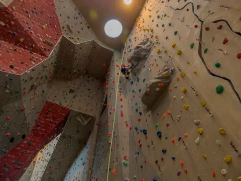 Artificial indoor climbing wall with unknown climber on it. Stock Photos