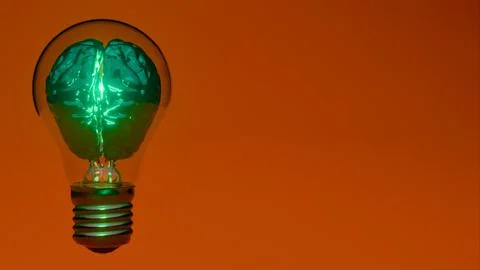 Artificial intelligence chip glowing inside light bulb over orange  backgroun 写真素材