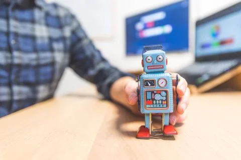 Artificial intelligence concept: Toy robot on office desktop. Metaphor for... Foto stock