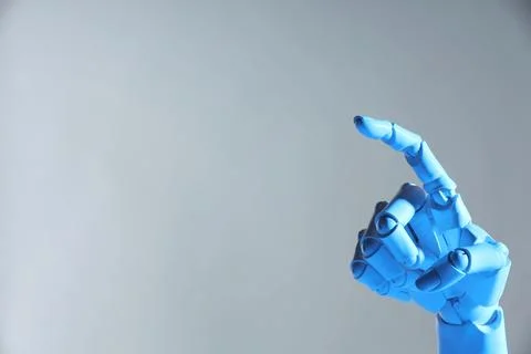 Artificial intelligence. Robot hand pointing at something on grey backgroun.. Stock Photos