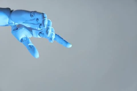 Artificial intelligence. Robot hand pointing at something on grey backgroun.. Stock Photos