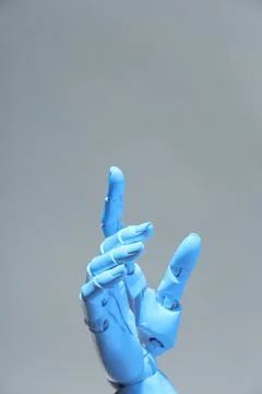 Artificial intelligence. Robot hand pointing at something on grey background Stock Photos