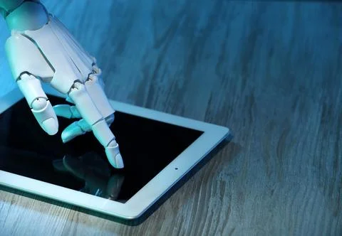 Artificial intelligence. Robot hand using tablet at wooden table, closeup. .. Stock Photos