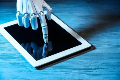 Artificial intelligence. Robot hand using tablet at wooden table, closeup Foto stock