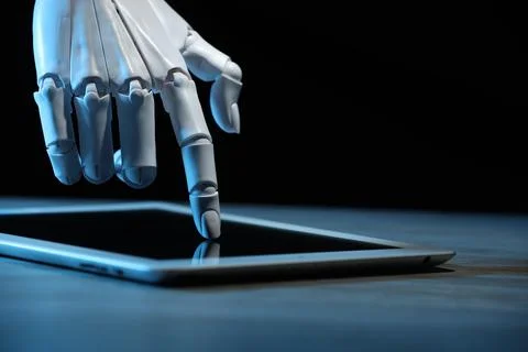 Artificial intelligence. Robot hand using tablet at table, closeup 库存照片