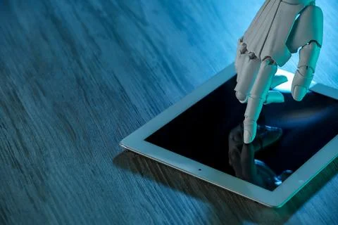 Artificial intelligence. Robot hand using tablet at wooden table, closeup. .. 스톡 사진